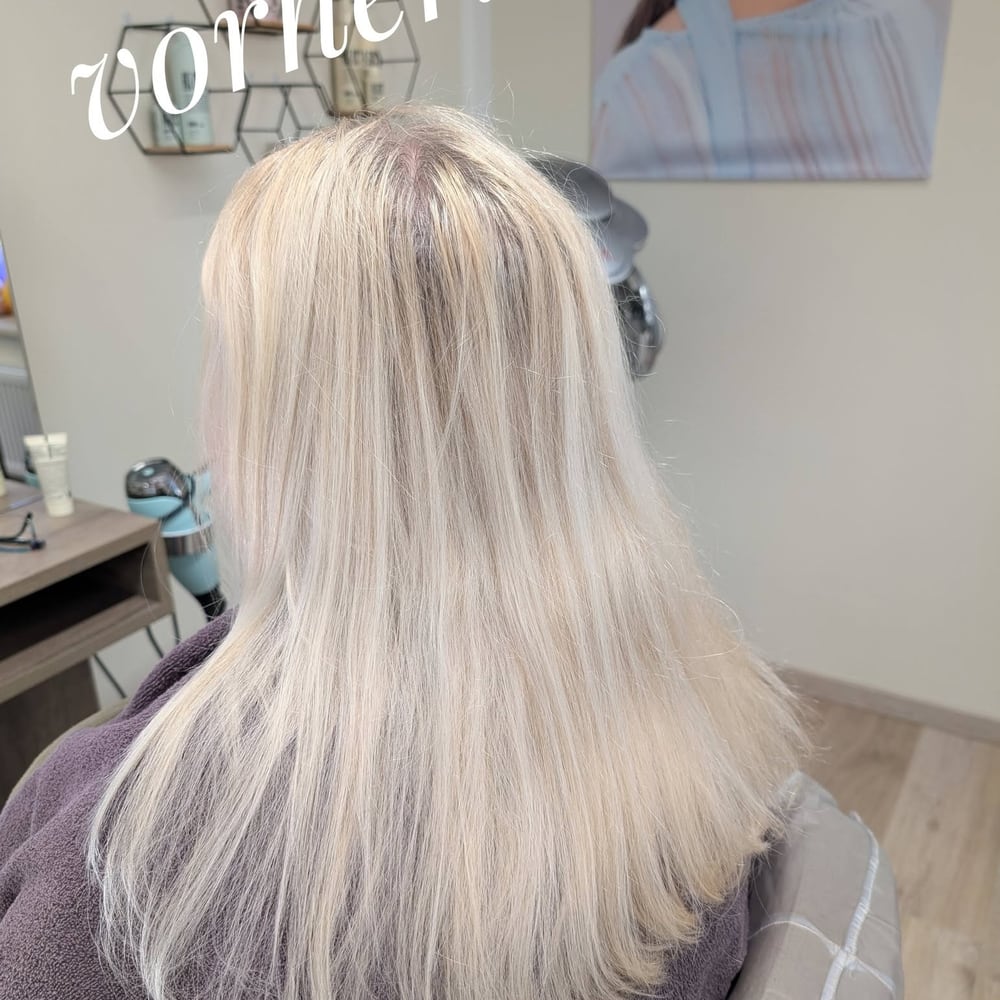 Langes blondiertes Haar von hinten, mit herausgewachsenem dunklerem Ansatz.